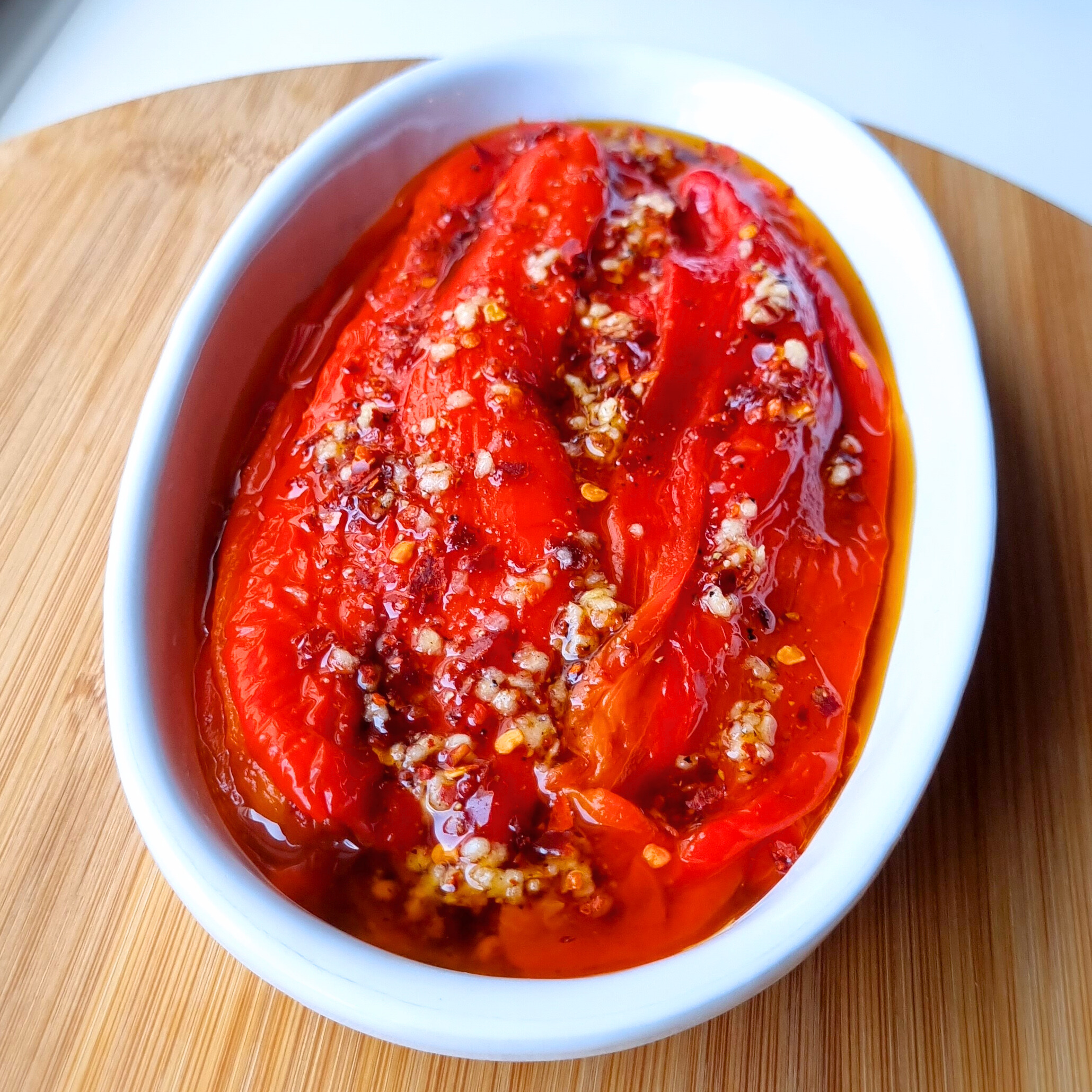 Vegan recept voor geroosterde puntpaprika uit de oven in een lekker pittige olijfolie met chiliflakes en knoflook