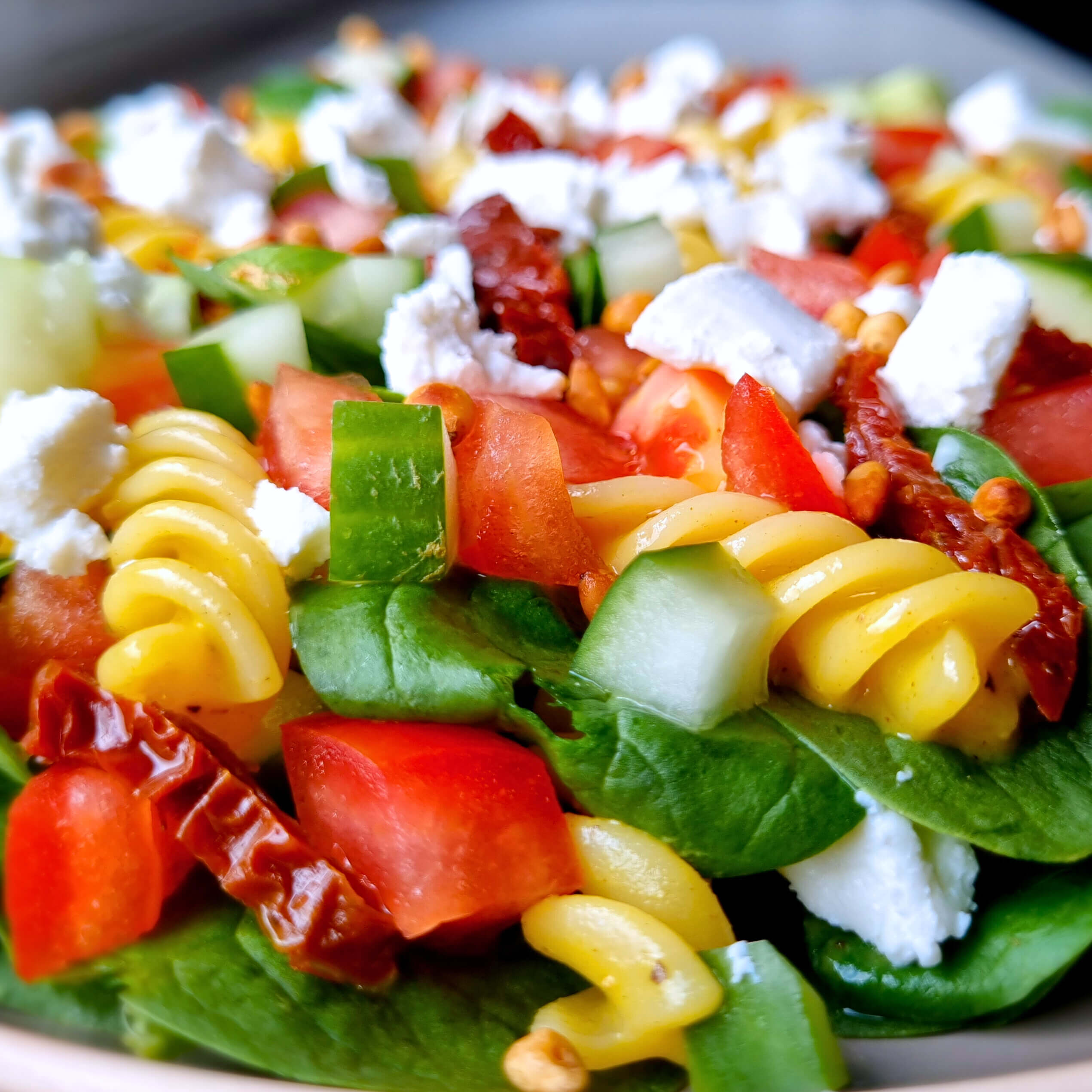 Een heerlijke, gezonde en goedkope lunch die je zó klaarmaakt. Met pasta, geitenkaas, geroosterde pijnboompitten en een honing-mosterddressing