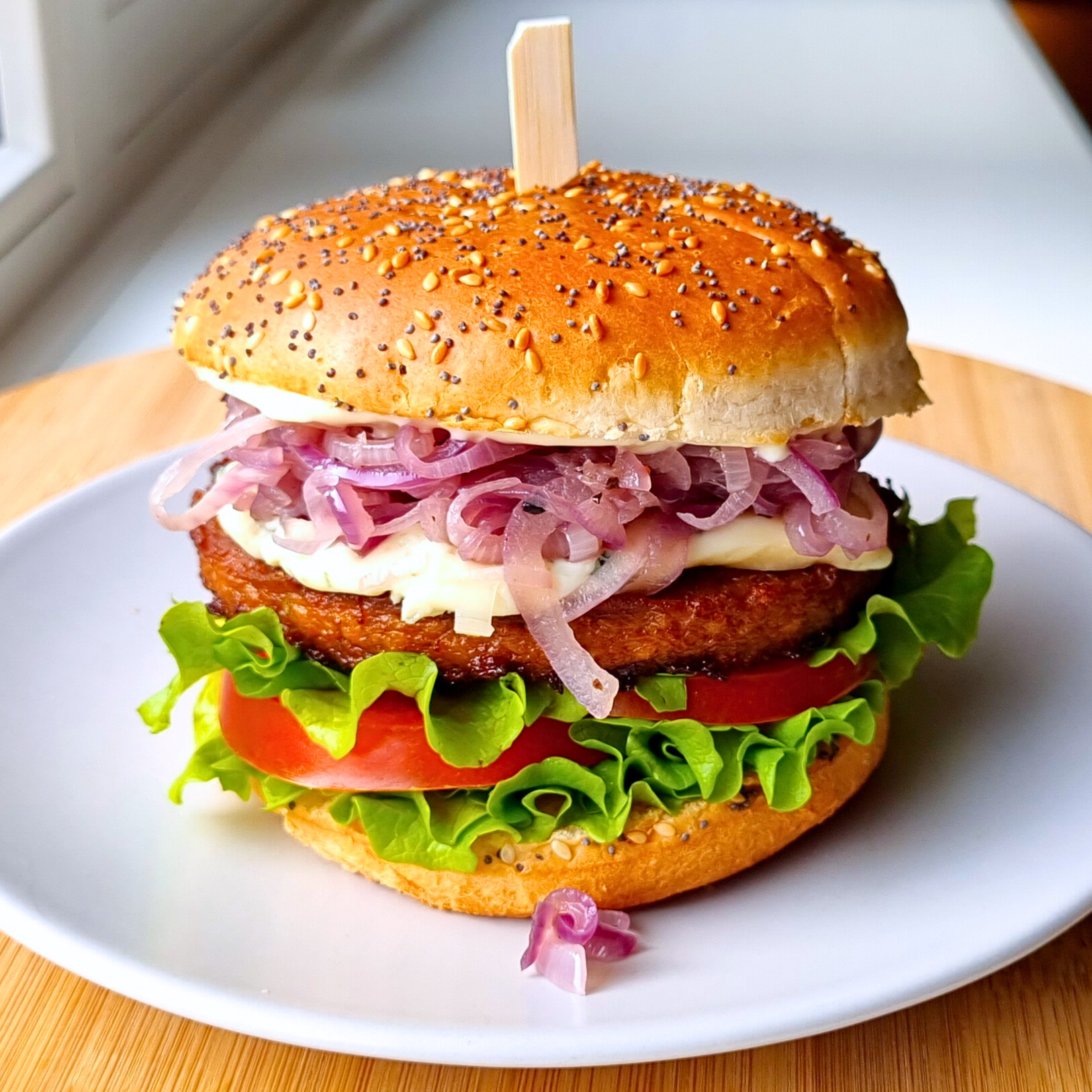 Hamburger met vega sojaburger, Viking blue blauwe kaas, gebakken rode ui, tomaat en Batavia sla