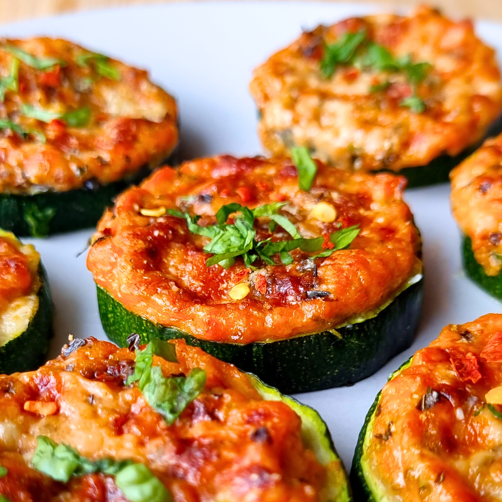 Heerlijke gezonde courgette mini pizzatjes met zongedroogde tomaat en ricottasaus en Parmezaanse kaas