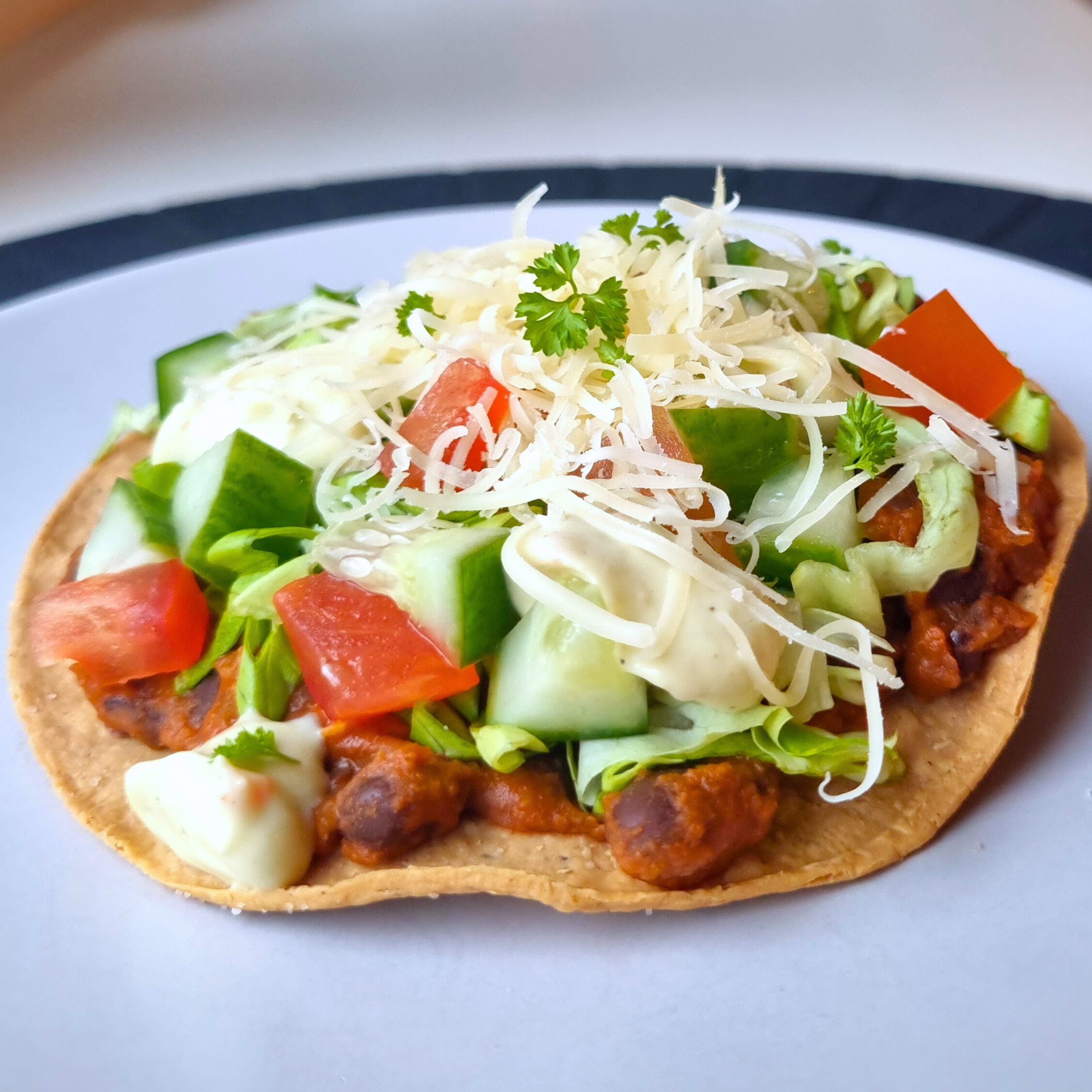 Vegetarische tostada met gekruide zwarte bonen & avocado-chilimayo