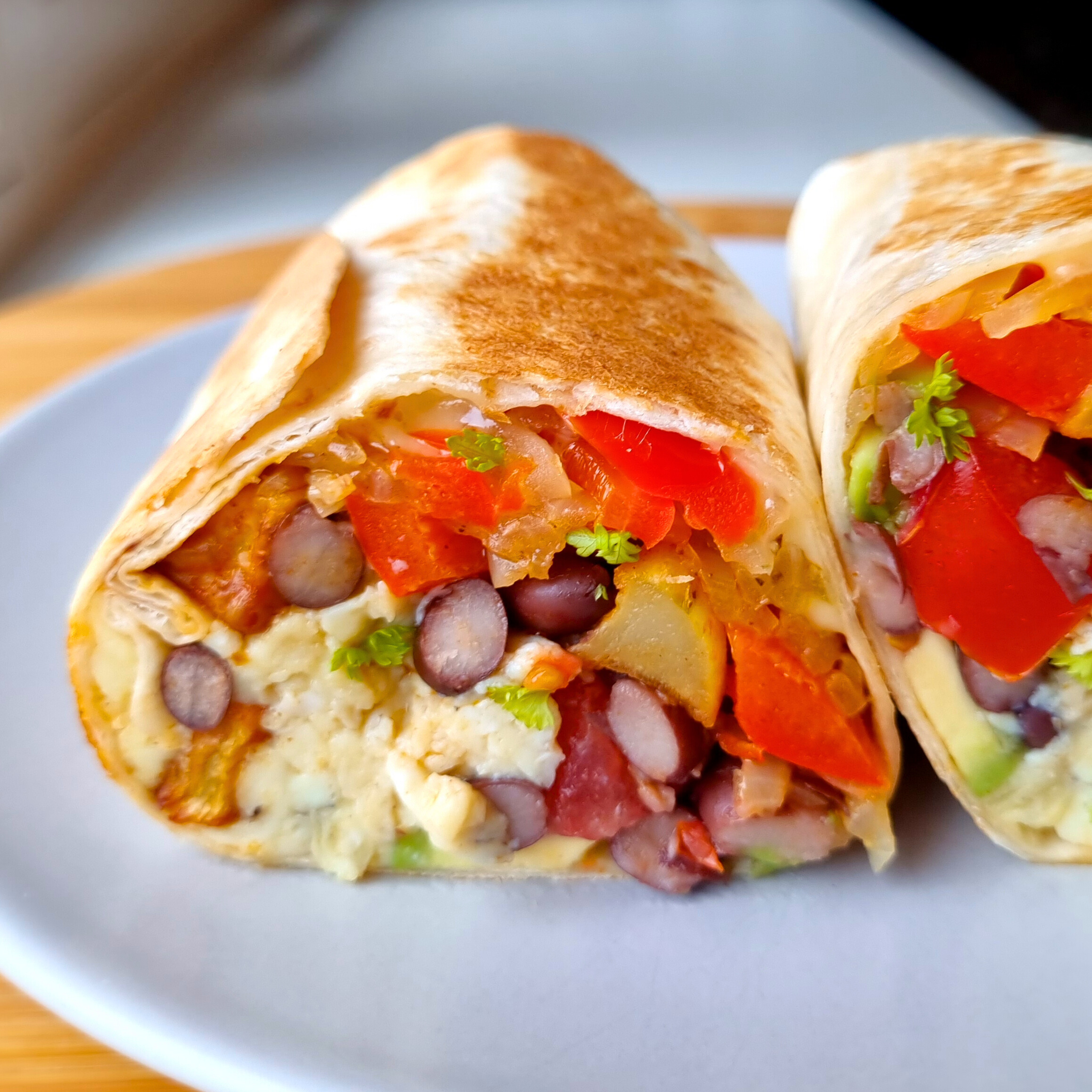 Breakfast burrito gevuld met scrambled eggs, rode puntpaprika, ui, avocado, jonge kaas, tomaat, aardappeltjes én zwarte bonen