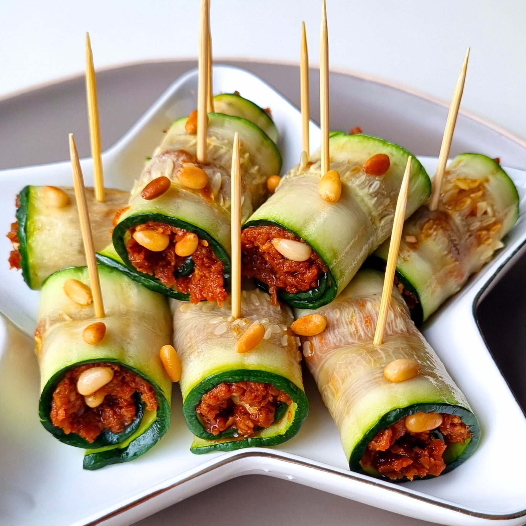 Gegrilde courgetterolletjes met tomaten tapenade en geroosterde pijnboompitten