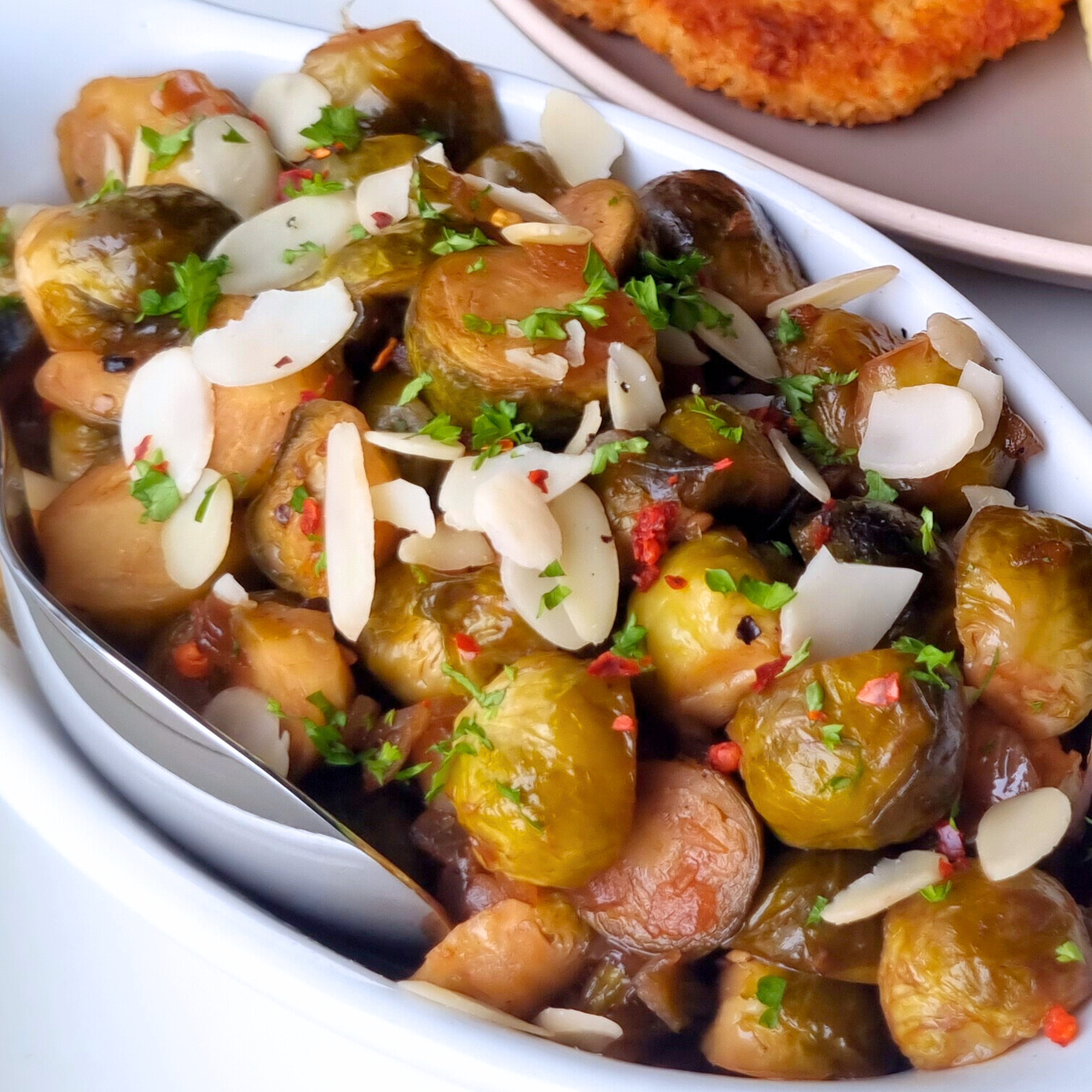 Spruitjes gebakken met knoflook, balsamico azijn & ahornsiroop. Afgemaakt met geschaafde amandelen (vegan recept)