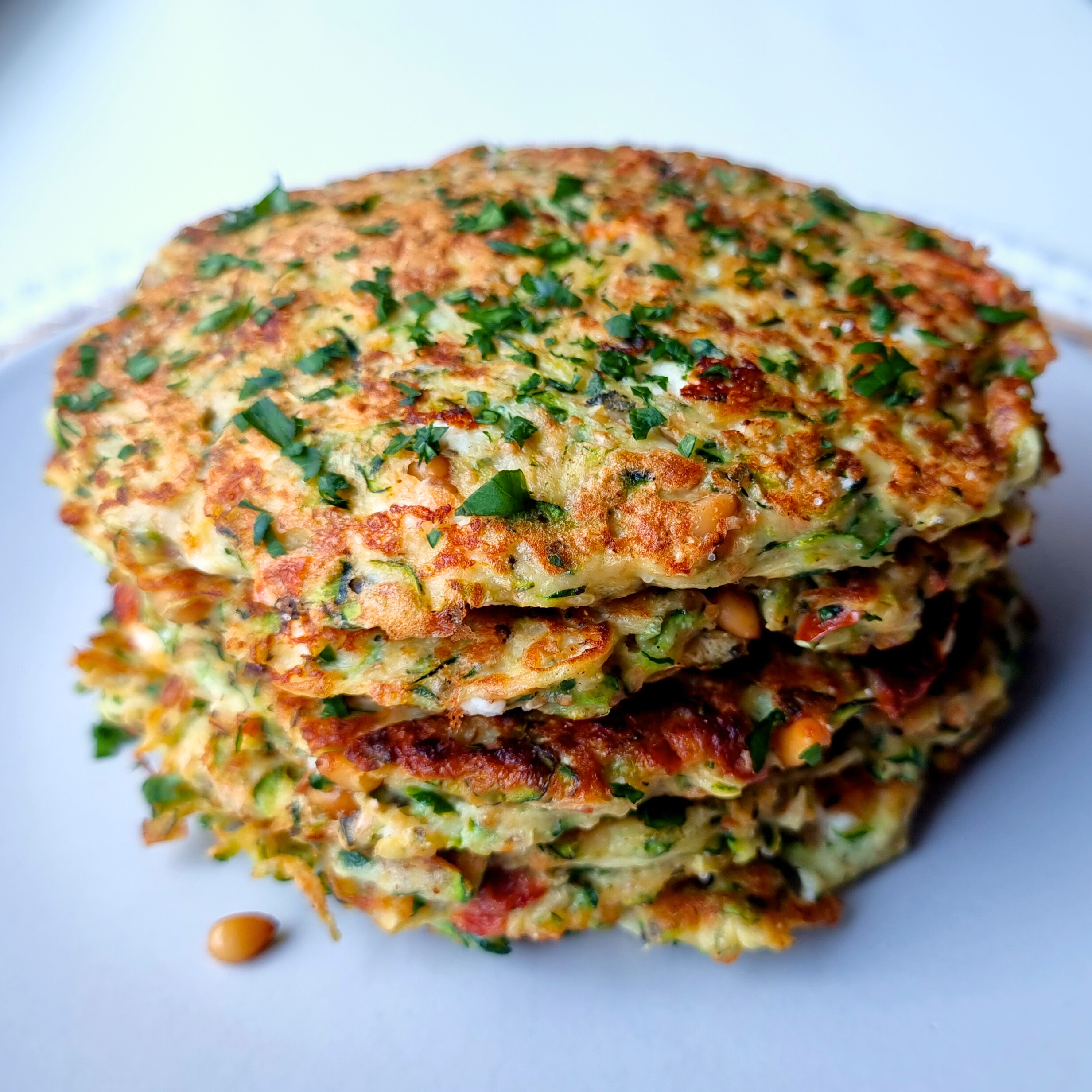 Courgette pancakes met geitenkaas, pijnboompitten & zongedroogde tomaat